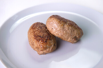 Close up of Two Meatballs served on gray plate. Russian traditional Homemade meat cutlets isolated on gray background. Slavic food menu

