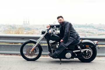 Fototapeta na wymiar biker sitting on his motorcycle on the road