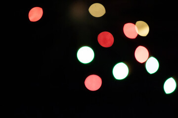 Multicolored bokeh spots on a black background.