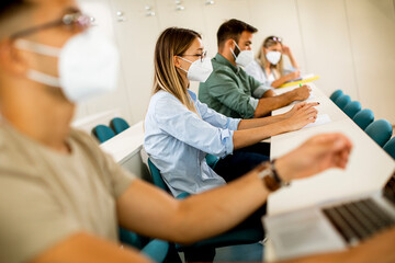 Female student wearing face protective medical mask for virus protection at lecture hall