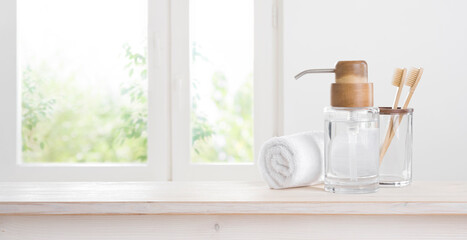 Wooden toothbrushes and eccentric soap dispenser against blurred window background
