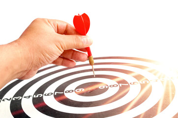 Close up shot red dart arrow on center of dartboard, metaphor to target success, winner concept,...