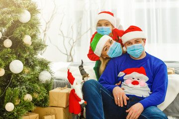family in protective masks quarantined. Normal life with coronavirus. Lifestyle COVID-19. Quarantine virus protection. christmas