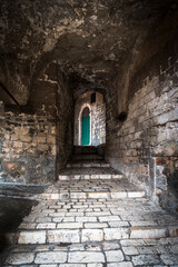 Fototapeta na wymiar Medieval narrow street with a green door in Sibenik, Croatia