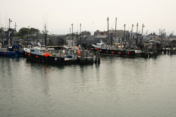 Fototapeta premium Narragansett, RI / United States - Sept. 15, 2020: wide view of the pier and fishing boats of the Point Judith harbor in Rhode Island.