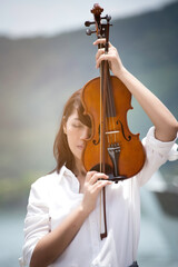 Beautiful asian woman hold violin on nature background, in emotion feeling happy.