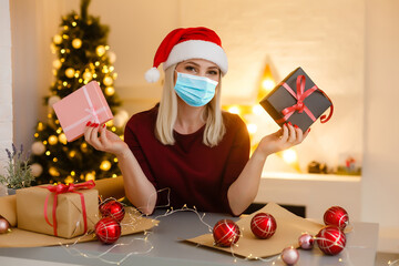 Easy to buy with online shopping! Satisfied young woman with medical mask holding christmas...