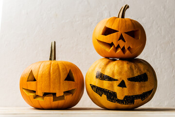 Three pumpkins on wooden table. Halloween and autumn food background