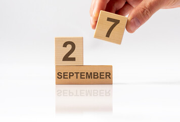 Cube shape calendar for SEPTEMBER 27 on white glossy background with reflection