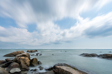 Reef or rock at beach with beautiful sea and blue sky with cloud in thailand at afternoon (long exposure)