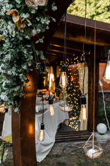 wedding arch decorated with flowers, lanterns and candles