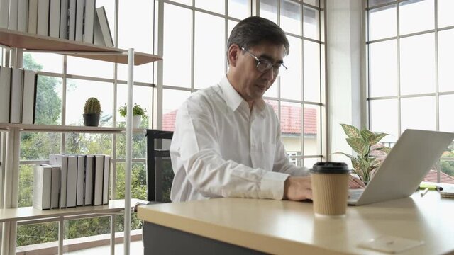 Young business asian man employee drinking coffe during working day.