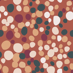 Green, light and maroon rocks simple silhouettes seamless pattern. Doodle masonry print with dark orange background.