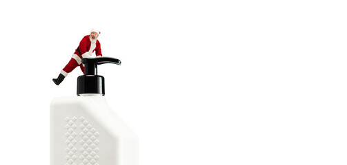 Naklejka premium Santa Claus with the huge antiseptics against COVID like Christmas gift isolated on white background. Man in traditional costume. New Year, winter, epidemic, pandemic concept. Copyspace. Flyer