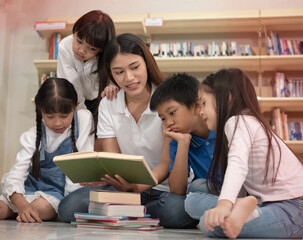 Beautiful lady and group of children reading book together,with intrersted feeling,blurry light around