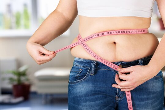 Female fat figure with measuring tape on blur background