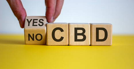 Male hand turns a cube and changes the words 'CBD yes' to 'CBD no' on wooden cubes. Beautiful...