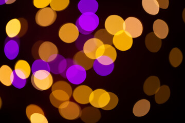 Christmas multicolored lights in defocus on a dark background