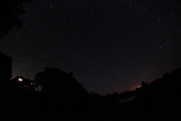 Blue dark night sky with many stars. Night sky over rural landscape. high ISO landscape with...