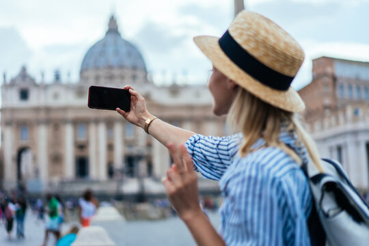 Hipster female tourist taking selfie in front of cathedral in Rome