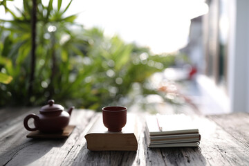 Traditional clay teapot and tea pot with books on old wooden table relax home outdoor workspace