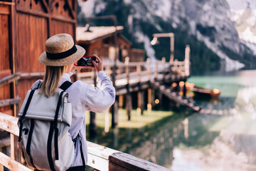 Female tourist taking photo of lake and Alps