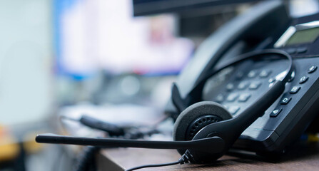 close up soft focus on headset with telephone devices at office desk for customer service support...