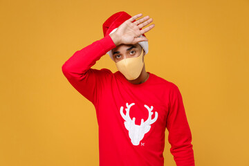 Tired sick Santa african american man in Christmas hat face mask to safe from coronavirus virus...