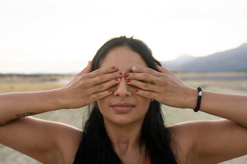 young girl touching her eyes with her hands