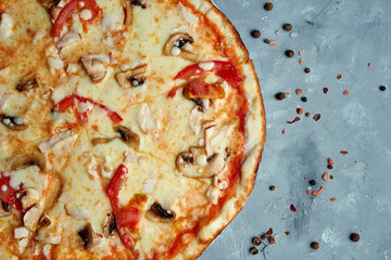 Italian pizza with bacon, mushrooms, tomatoes, melted cheese on a gray background. Top view, food flat lay