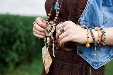 Close-up picture of female hands. holding wooden curved necklace. Traditional authentic jewelry. Hippie woman decorations.
