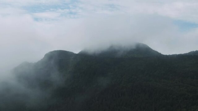Clouds At The Peak Of The Lush Green Forest In Mont Sainte Anne, Quebec, Canada In Spring - aerial