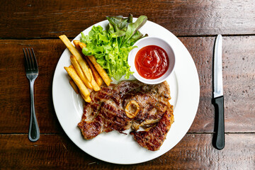 Pork Chop Steak Grilled steaks, French fries and vegetables