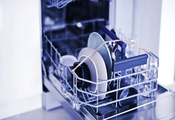 Open dishwasher with clean dishes background