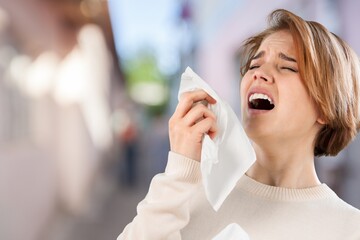 Allergies or cold concept. Young woman blowing nose