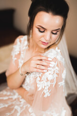 Obraz na płótnie Canvas Beautiful bride wearing fashion wedding dress with feathers with luxury delight make-up and hairstyle, studio indoor photo shoot