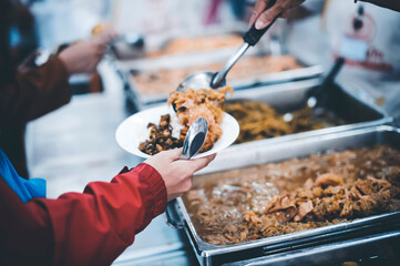 Food donation to help people in hunger relief : hands of the poor receive food from the donor's share
