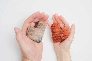 Knitted hearts in a man's and a woman's hand
