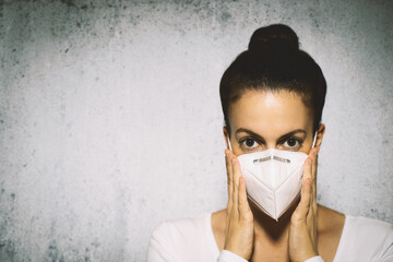 Woman putting on mask. Infection prevention.