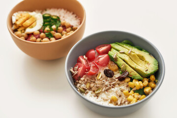 Healthy lunch ideas, Close up of two bowl with sliced vegetables and rice isolated over white background