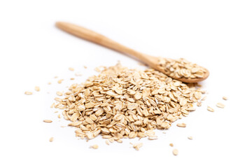 A full wooden spoon behind a pile of oat flakes