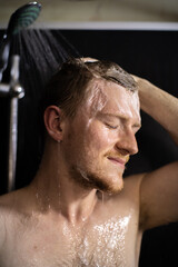 young ginger bearded naked man washing his hair taking shower with shampoo foam. Calm and balanced man enjoying water jets while showering