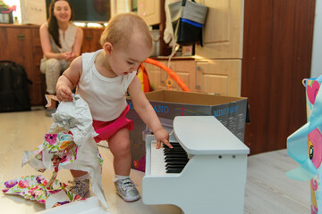 Baby girl 1 year old eating birthday cake in room. Birthday party. Childhood