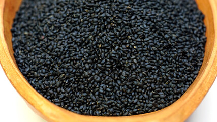 Basil seeds in an orange clay bowl.