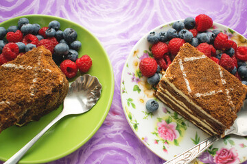 Two pieces of chocolate cake on plates with berries. Beautiful dessert