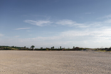 Fototapeta na wymiar Large gravel background site with cloudy sky