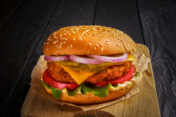 Beef burger with melted cheese and bacon on wooden background