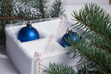 The Christmas decoration on a white background in a beautiful package. The New Year's gifts with a sprig of spruce.