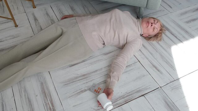 An elderly woman lies unconscious on the floor of a house