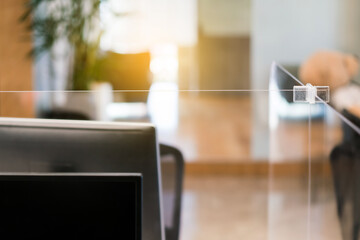 Acrylic plexiglass separator setting on the desk in the office. New normal Concept for social...